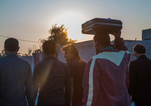 man carrying the new clorthes of the groom in a suitcase during a wedding ceremony, Hormozgan, Kushkenar, Iran