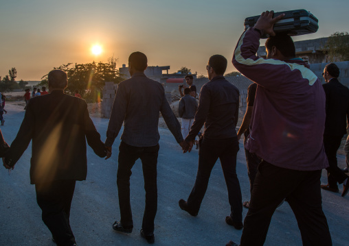 man carrying the new clorthes of the groom in a suitcase during a wedding ceremony, Hormozgan, Kushkenar, Iran