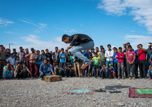 man jumping on broken glass during a show on a market, Hormozgan, Minab, Iran