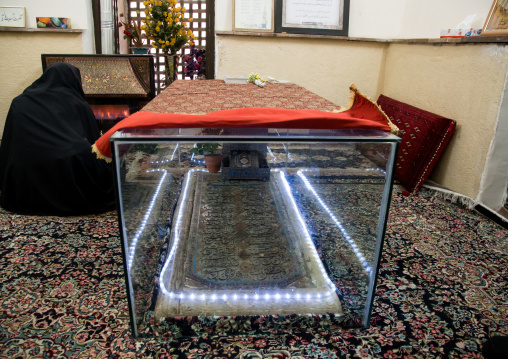 women in black chadors resting in front of a fireplace inside three domes moshtaghie, Central County, Kerman, Iran