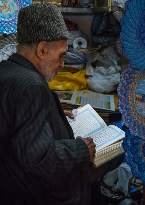 old man reading koran in his shop, Isfahan Province, isfahan, Iran