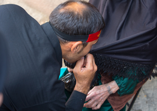 Shiite Man Kissing The Dark Clothes Of His Mother For Chehel Menbari Festival On Tasua Day To Commemorate The Martyrdom Of Hussein, Lorestan Province, Khorramabad, Iran