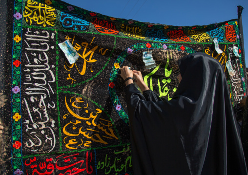 Iranian Shiite Muslim Women Covered In Mud Attaching Bank Notes On A Flag During Ashura, The Day Of The Death Of Imam Hussein, Kurdistan Province, Bijar, Iran