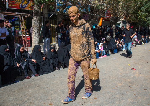 Iranian Shiite Muslim Man Covered In Mud With A Bucket During Ashura Day, Kurdistan Province, Bijar, Iran