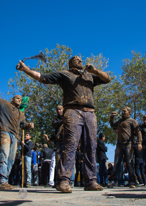 Iranian Shiite Men Covered In Mud Are Beating Themselves With Iron Chains During Ashura, The Day Of The Death Of Imam Hussein, Kurdistan Province, Bijar, Iran