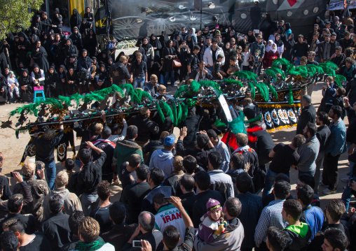 An Iranian Man Carries An Alam Is Helped By Shiite Mourners To Bow In Front Of A Mosque On Ashura, The Day Of The Death Of Imam Hussein, Kurdistan Province, Bijar, Iran