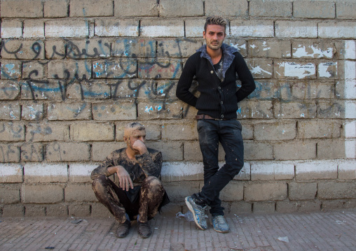 Iranian Shiite Muslim Men Covered In Mud, Resting Against A Wall After Ashura Ceremony, Kurdistan Province, Bijar, Iran