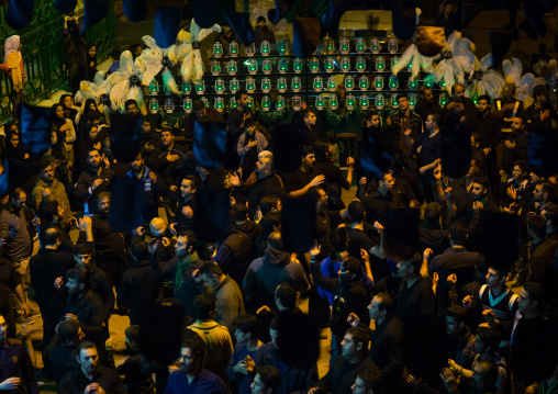 Shiite Muslim Mourners In Front Of An Alam With Forty Lamps On Ashura, The Day Of The Death Of Imam Hussein, Golestan Province, Gorgan, Iran