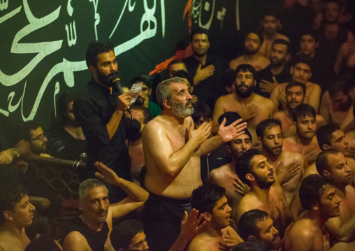 Iranian Shiite Muslim Man Leading Recitations And Songs With The Mad Of Hussein Mourners During Muharram, Isfahan Province, Kashan, Iran