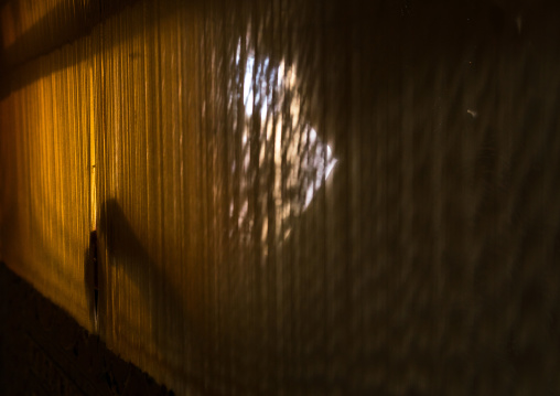 Silhouette Of An Afghan Refugee Woman Making A Carpet In Her House, Isfahan Province, Kashan, Iran