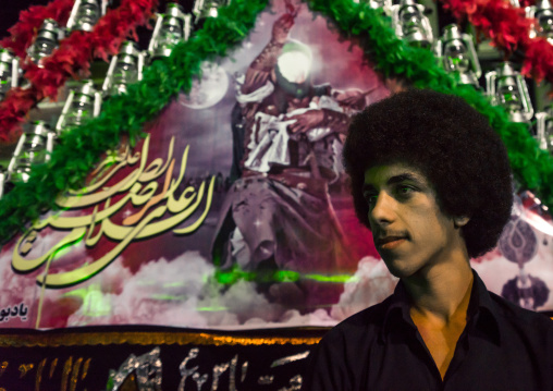 Young Iranian Shiite Muslim Man Mourner Pausing Proudly In Front Of An Alam On Ashura, The Day Of The Death Of Imam Hussein, Isfahan Province, Kashan, Iran