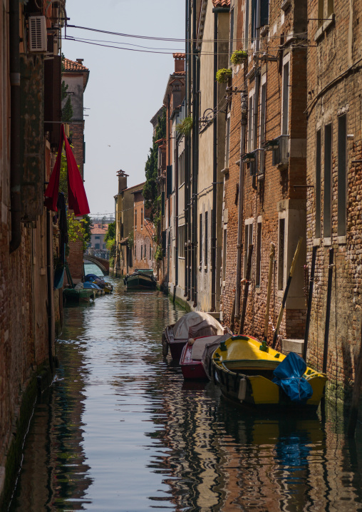 Venetian decayed facades and reflections on a canal, Veneto Region, Venice, Italy