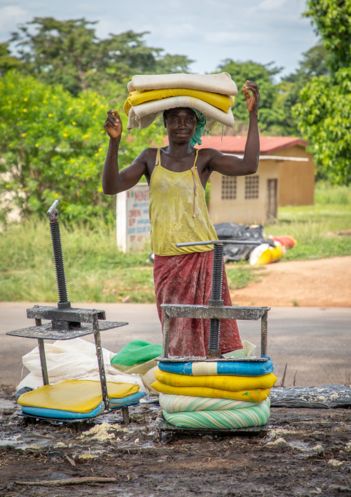 African woman putting attiéké in bags, Région des Lacs, Sakiare, Ivory Coast