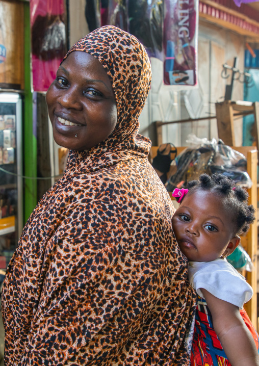 African mother carrying her child girl in her back, Comoé, Abengourou, Ivory Coast