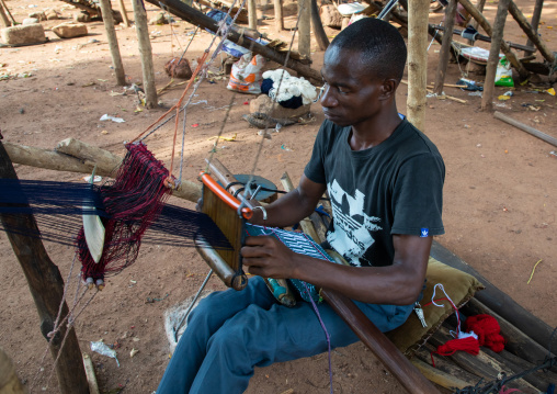 African man from Senufo tribe weaving in a traditional textile factory, Savanes district, Waraniene, Ivory Coast