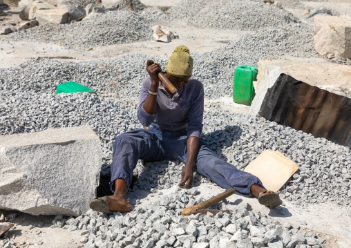 African woman crashing stones in a granite quarry, Savanes district, Shienlow, Ivory Coast