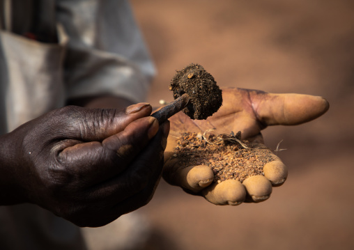 Senufo blacksmith using a magnet to find the metal, Poro region, Koni, Ivory Coast