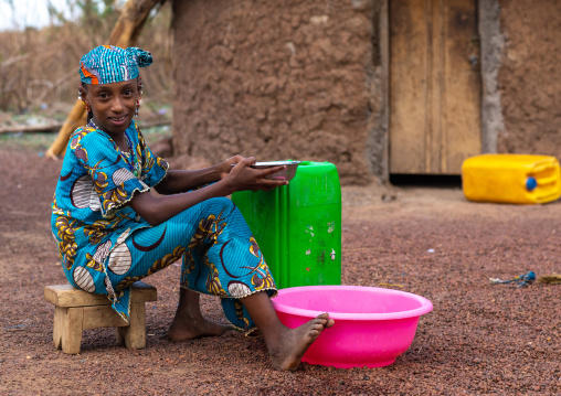 Portrait of a Peul tribe girl with plastic bucket, Savanes district, Boundiali, Ivory Coast