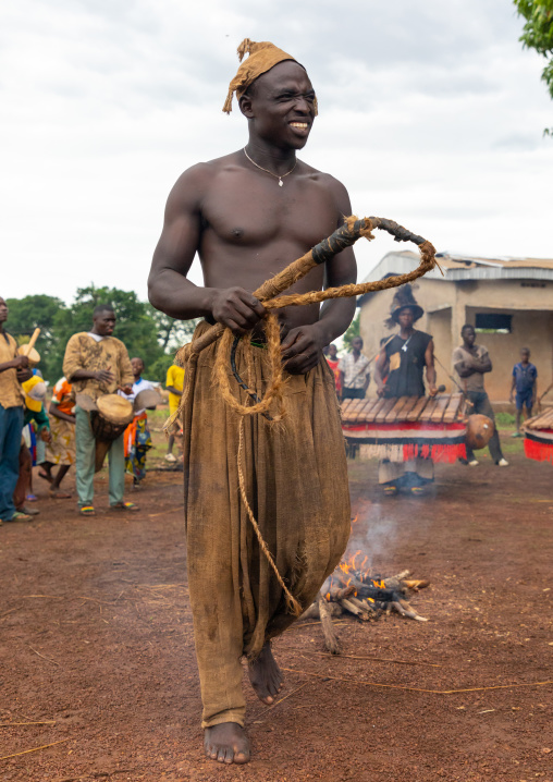 Young Senufo shirtless man dancing the Ngoro with a whip during a ceremony, Savanes district, Ndara, Ivory Coast