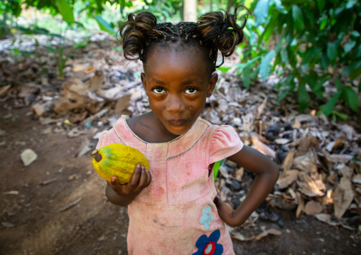 Cute african girl with a cocoa fruit pod in her hands, Région des Lacs, Yamoussoukro, Ivory Coast