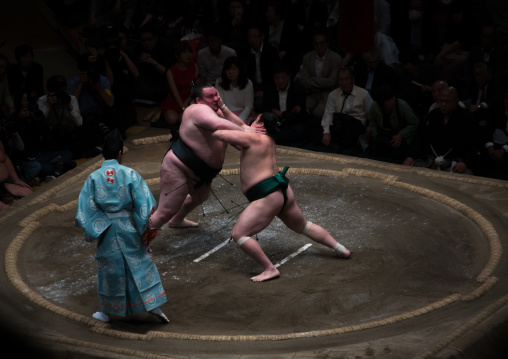 Two sumo wrestlers fighting at the ryogoku kokugikan arena, Kanto region, Tokyo, Japan