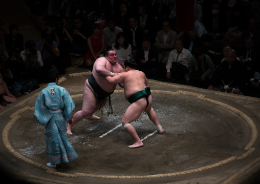 Two sumo wrestlers fighting at the ryogoku kokugikan arena, Kanto region, Tokyo, Japan