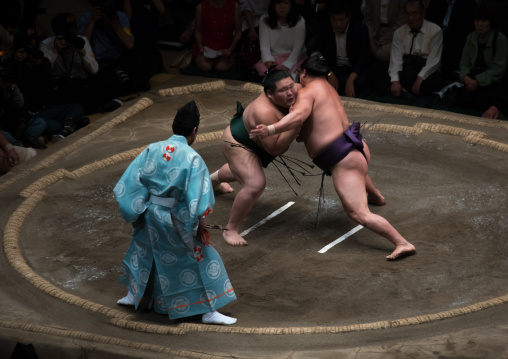 Two sumo wrestlers fighting at the ryogoku kokugikan arena, Kanto region, Tokyo, Japan