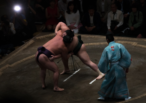 Two sumo wrestlers fighting at the ryogoku kokugikan arena, Kanto region, Tokyo, Japan