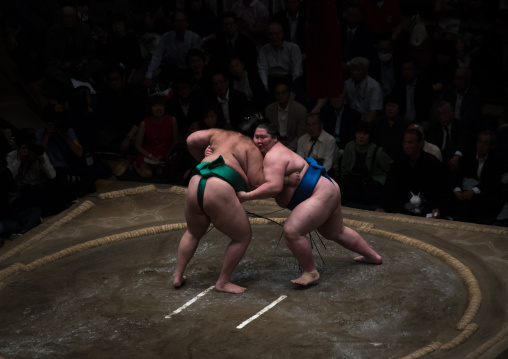 Two sumo wrestlers fighting at the ryogoku kokugikan arena, Kanto region, Tokyo, Japan