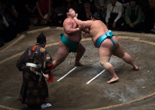 Two sumo wrestlers fighting at the ryogoku kokugikan arena, Kanto region, Tokyo, Japan