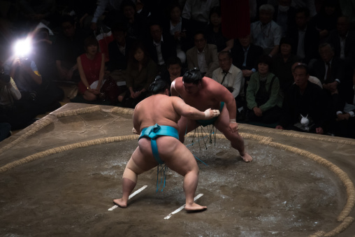 Two sumo wrestlers fighting at the ryogoku kokugikan arena, Kanto region, Tokyo, Japan