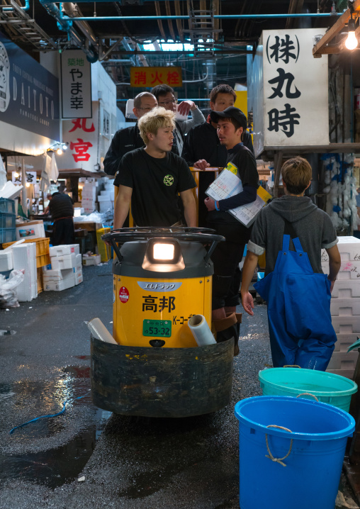 Workers on a a motorized cargo cart called a taretto, Kanto region, Tokyo, Japan