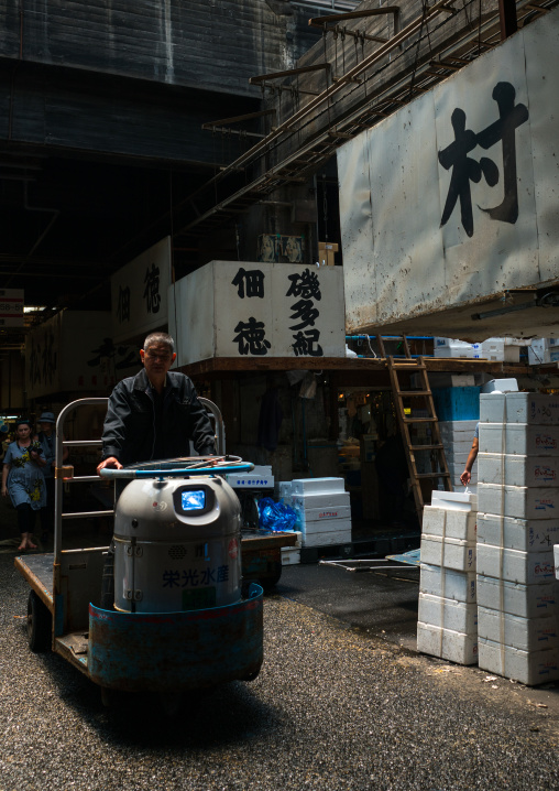 A man driving a motorized cargo cart called a taretto, Kanto region, Tokyo, Japan