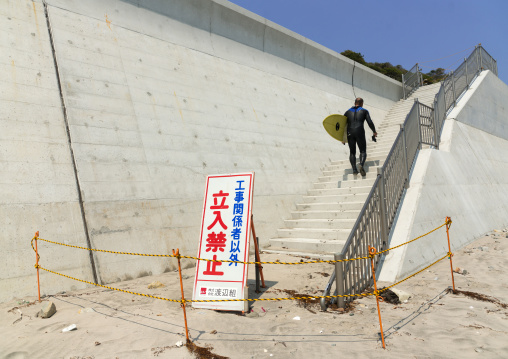 A authorized entry prohibited sign
 in front of a japanese surfer in the contaminated area after the daiichi nuclear power plant irradiation, Fukushima prefecture, Tairatoyoma beach, Japan