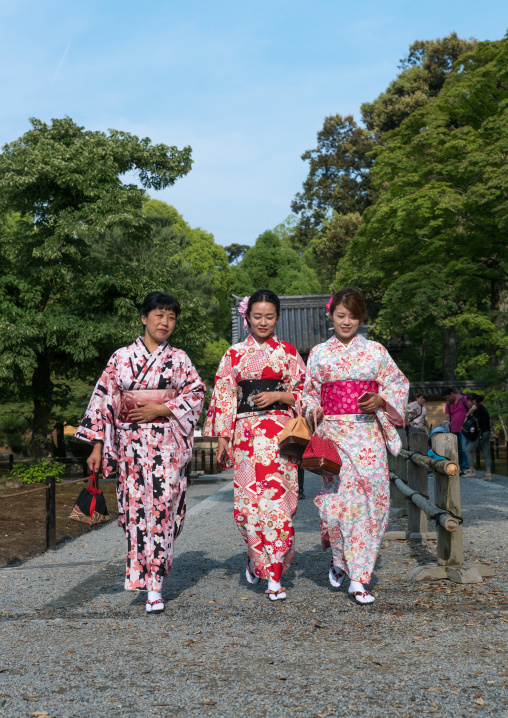 Chinese tourist women wearing geisha kimonos in a zen garden, Kansai region, Kyoto, Japan