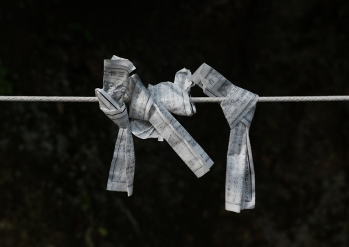 Folded paper fortunes tied to wires on a board, Kansai region, Kyoto, Japan