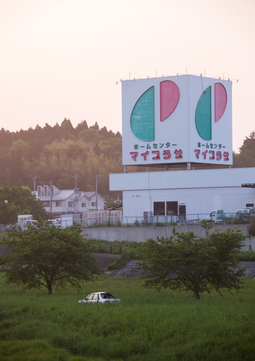 A destroyed and abandoned car by 2011 tsunami in front of my plaza home center building, Fukushima prefecture, Tomioka, Japan