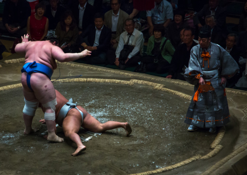 Two sumo wrestlers fighting at the ryogoku kokugikan arena, Kanto region, Tokyo, Japan