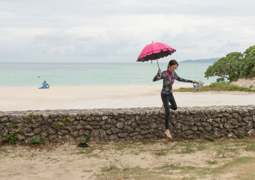 Japanese woman with an umbrella in kondoi beach, Yaeyama Islands, Taketomi island, Japan