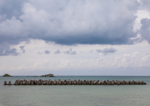 Concrete made tetrapods along the harbour in order to absorb the power of waves against storm clouds, Yaeyama Islands, Taketomi island, Japan