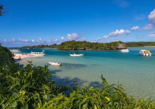 Glass bottom boats in the tropical lagoon beach with clear blue water and white sand in Kabira bay, Yaeyama Islands, Ishigaki, Japan