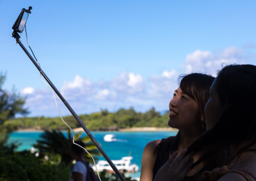 Japanese tourists taking selfie in Kabira bay, Yaeyama Islands, Ishigaki, Japan