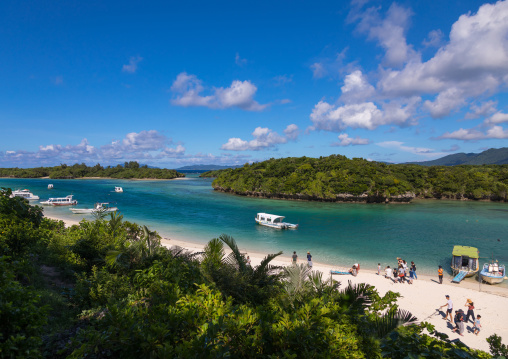 Glass bottom boats in the tropical lagoon beach with clear blue water and white sand in Kabira bay, Yaeyama Islands, Ishigaki, Japan