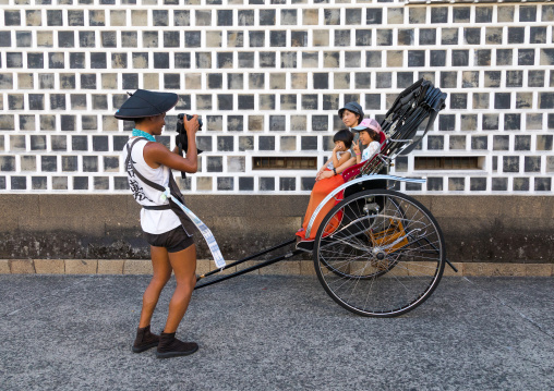 Rickshaw driver taking a picture of tourists in Bikan historical quarter, Okayama Prefecture, Kurashiki, Japan