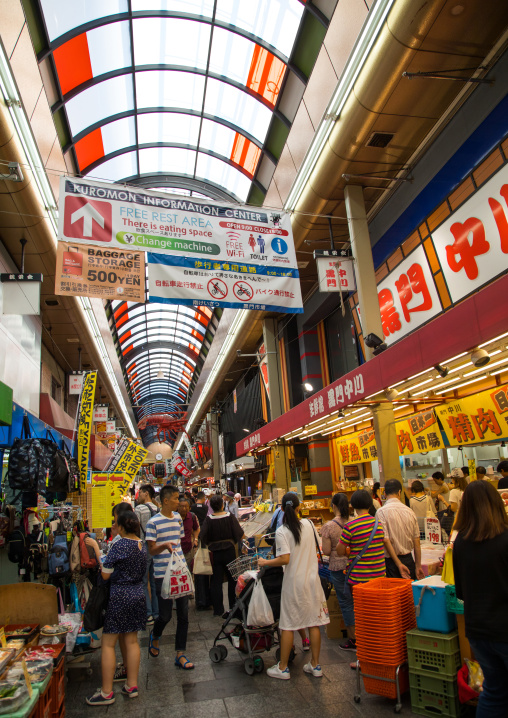 Shoppers walk along Kuromon Ichiba market, Kansai region, Osaka, Japan