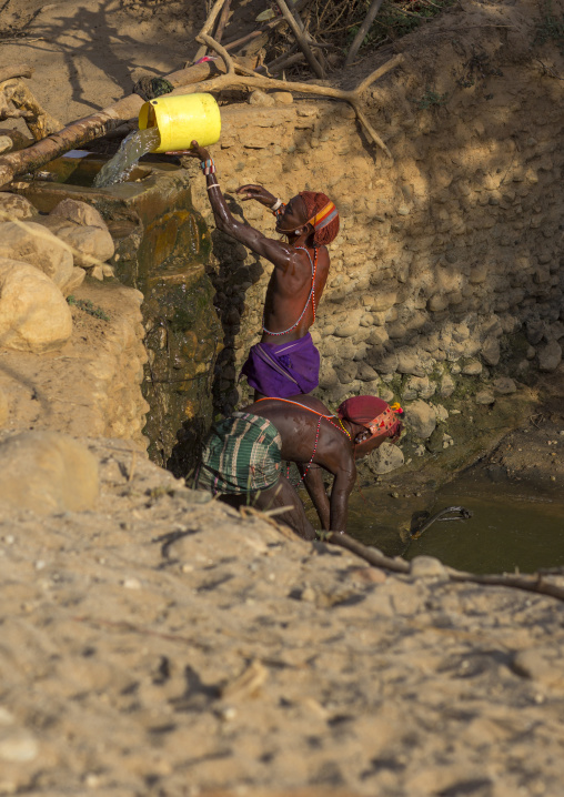 Rendille tribe men taking water in a singing well for their camels, Marsabit district, Ngurunit, Kenya