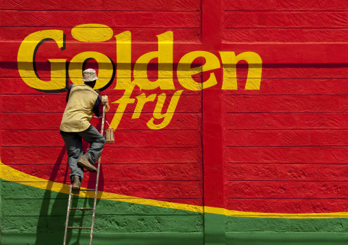 Man painting an adverstisement billboard, Rift Valley Province, Maasai Mara, Kenya