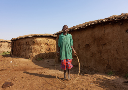 Maasai boy jumping rope in his village, Rift Valley Province, Maasai Mara, Kenya