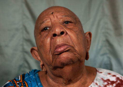 Portrait of a senior woman with shaved head and enlarged earlobes, Lamu County, Siyu, Kenya