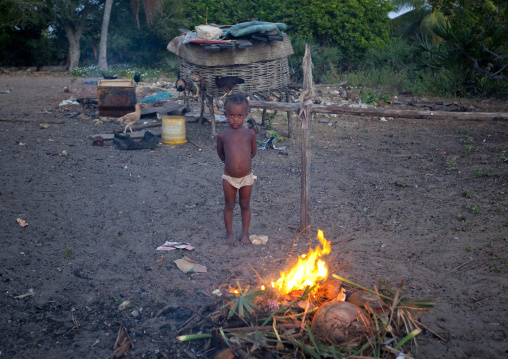 Little girl standing in front of a firecamp, Lamu County, Lamu, Kenya